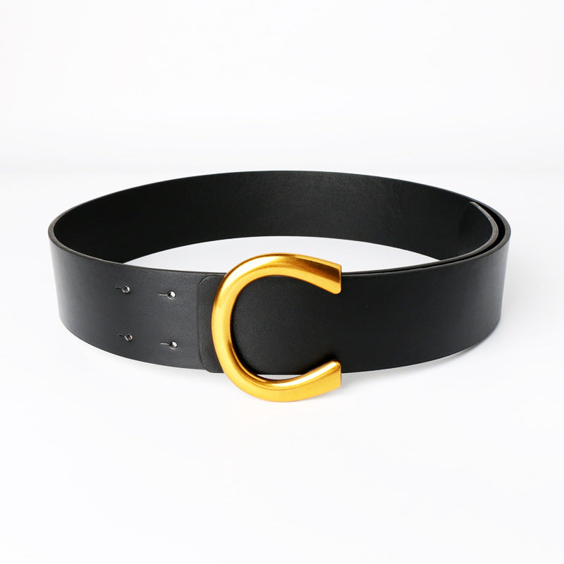 Ceinture large à boucle fer à cheval géométrique avec un tailleur et une jupe