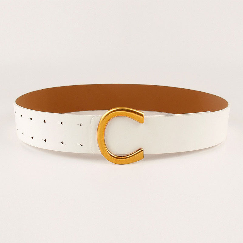 Ceinture large à boucle fer à cheval géométrique avec un tailleur et une jupe